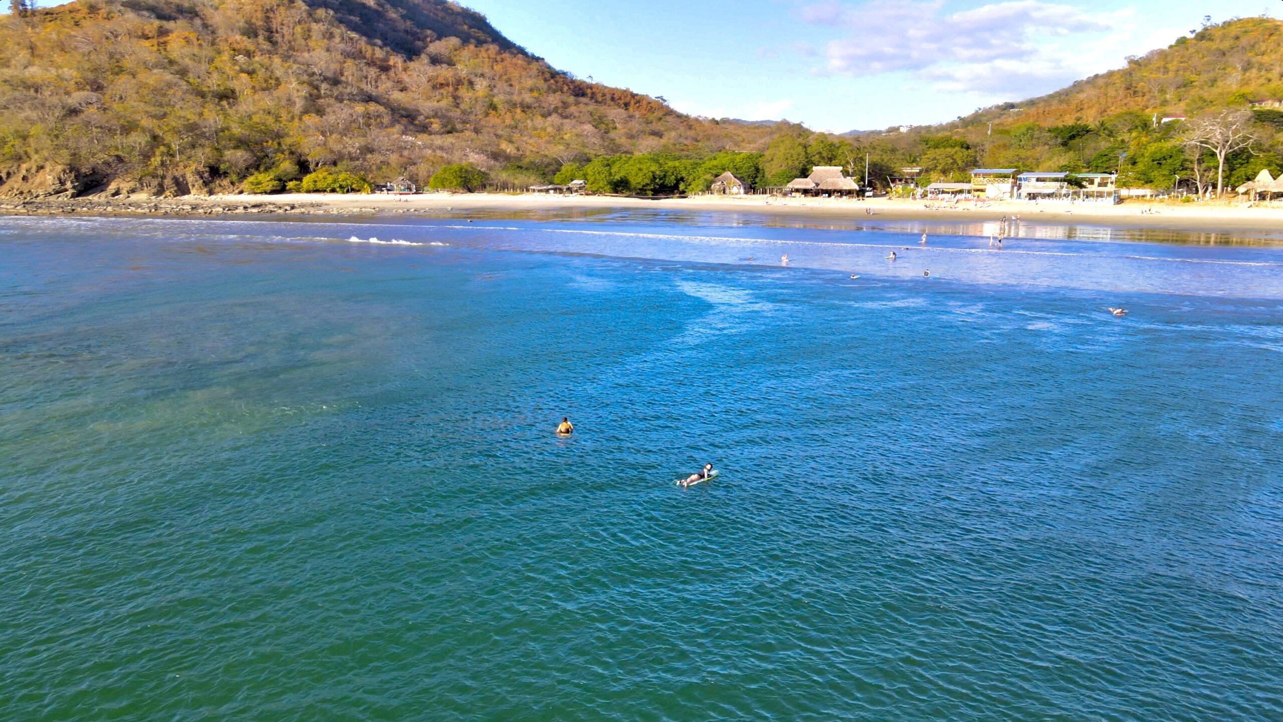Aerial view of Playa Remanso, San Juan del Sur — surfers in the bay