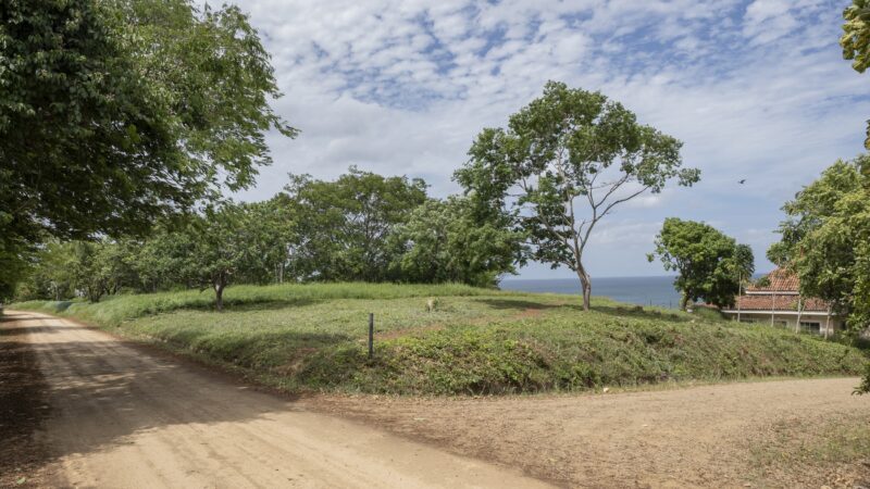 A stunning view of Rancho Santana Prime Corner lot showcasing lush greenery, and expansive views of the ocean.