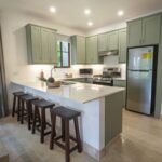 Kitchen with sage-green cabinetry and a center island