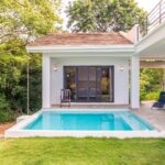 Private pool beside a modern villa with covered patio and lounge chairs in Rancho Santana.