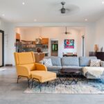 Spacious living room with sectional sofa, lounge chair, and open kitchen in a Rancho Santana villa.