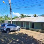 Lakefront Property with Commercial Potential with fenced shoreline, tree by the water, and distant mountains.