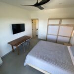 bedroom with ceiling fan and. tv in Panoramic Bay View Home