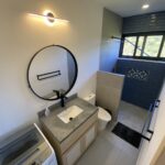 bathroom with a mirror and sink in Panoramic Bay View Home
