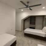 there single beds bedroom with air conditioning and ceiling fan in Turnkey Bay View Condo