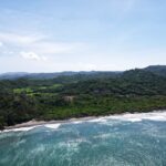 Aerial of the green hills meeting the ocean