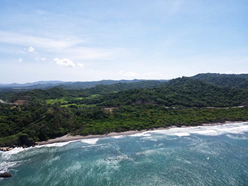 Aerial of the green hills meeting the ocean