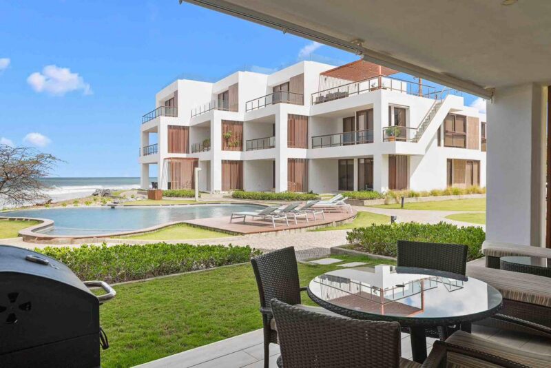 Covered terrace with a dining set facing the pool and the ocean