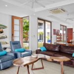 Living space with a surfboard rack beside the entry doors