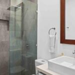Tiled bathroom with a glass shower and a vessel sink