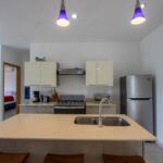 Modern kitchen with island, quartz counters, and stainless appliances