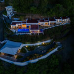 Twilight aerial of the Pacific Marlin Estate with its infinity pool glowing above the bay