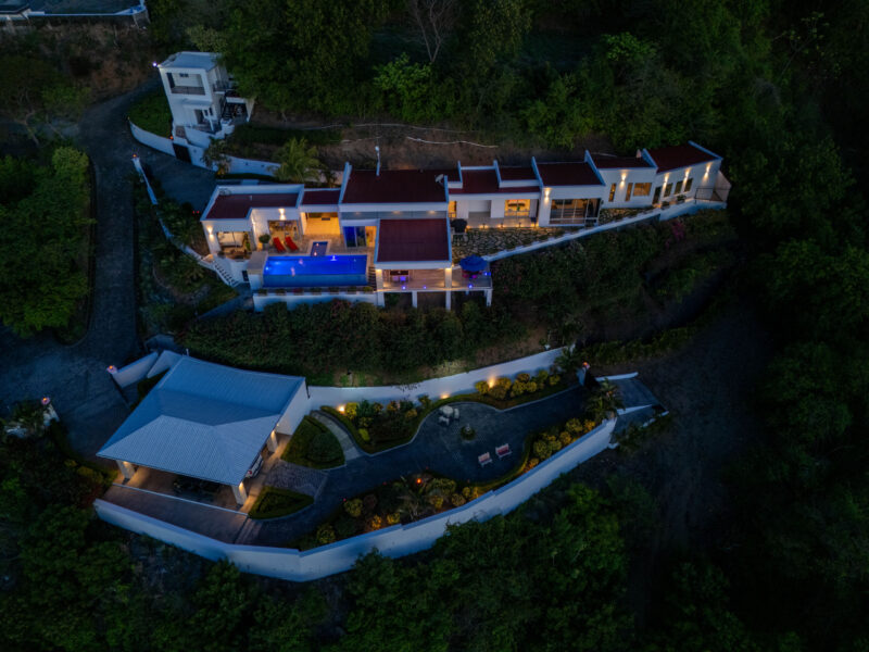 Twilight aerial of the Pacific Marlin Estate with its infinity pool glowing above the bay