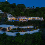 Daytime drone view of the hillside villa and its terraces over the ocean