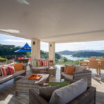 Shaded outdoor living area with sofas and bay views
