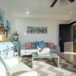 Bright sitting room with coastal artwork and light furnishings