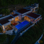 Twilight exterior of the villa with the infinity pool aglow