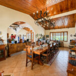 Open dining and living hall under a timber ceiling