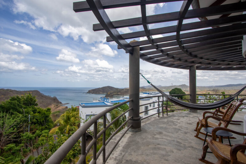 Shaded pergola terrace with a hammock overlooking San Juan del Sur bay
