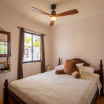Guest bedroom with a ceiling fan and garden views