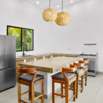 Kitchen with a polished concrete island and barstool seating
