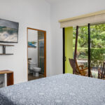 Master bedroom with a wall-mounted TV and garden window