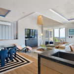 Dining and living space framed by walls of glass