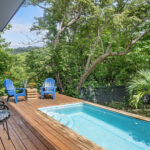 Poolside deck with loungers and forest views