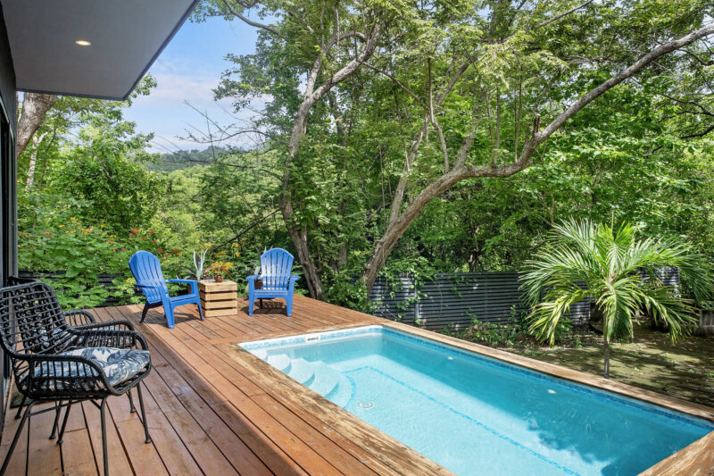 Poolside deck with loungers and forest views