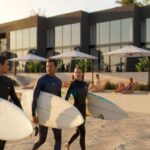 Surfers walking the sand at sunset