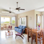 Open living and dining room with ocean views at the Rio Dulce penthouse in Hacienda Iguana