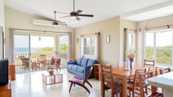 Open living and dining room with ocean views at the Rio Dulce penthouse in Hacienda Iguana