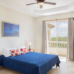 Primary bedroom with a private balcony and ocean view