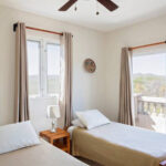 Guest bedroom with two twin beds and balcony access