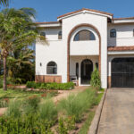 Front exterior with an arched garage and driveway