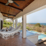 Shaded porch with a hammock overlooking the pool and sea