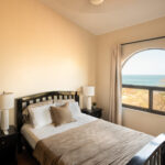 Primary bedroom with an arched window and sea view