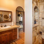 Bathroom with a stone shower and wood vanity