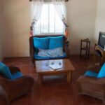 Living room with rattan seating and teal cushions
