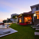 Hillside villa lit at dusk above the bay
