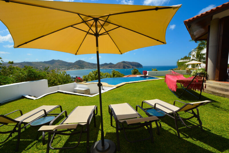 Poolside lawn with lounge seating and ocean view