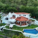 Bay-view home in Pacific Marlin — aerial from the hillside road
