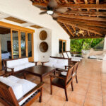 Covered terrace with dining and a hammock over the ocean