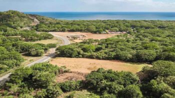 Aerial of the Costanera Highway commercial lot with the ocean and Hacienda Iguana beyond