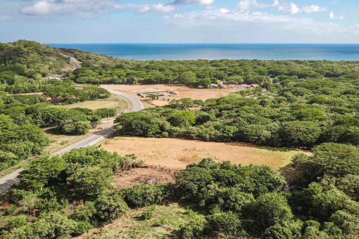 Aerial of the Costanera Highway commercial lot with the ocean and Hacienda Iguana beyond