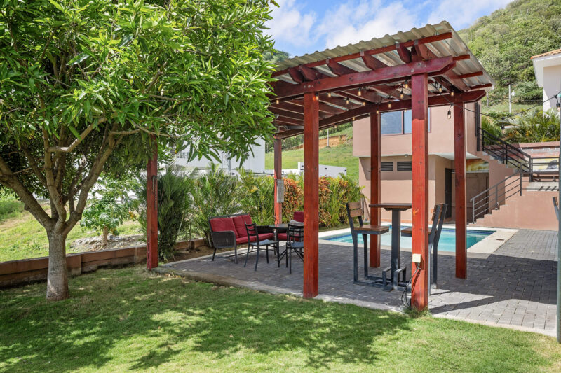 Pool and pergola beside the grass backyard