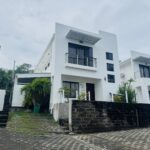 Two-story white villa facade with balcony in Colinas de Miramar