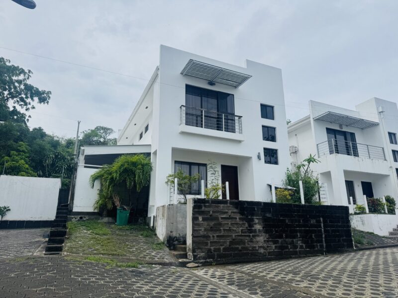 Two-story white villa facade with balcony in Colinas de Miramar