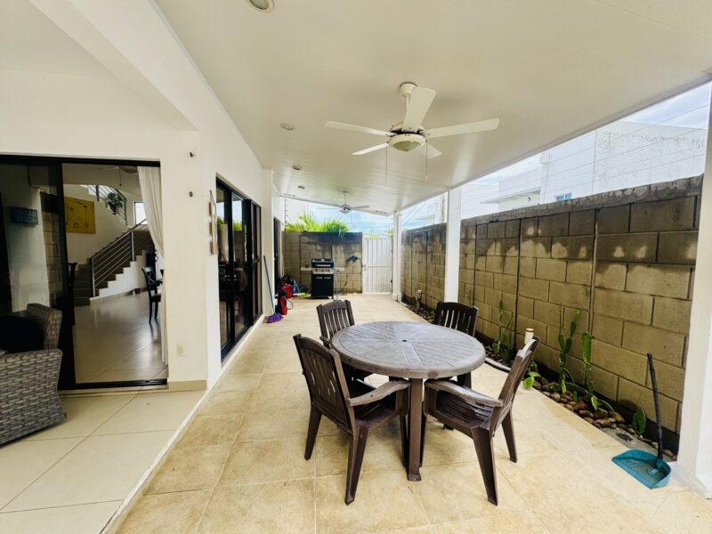 Covered terrace with dining table beside the pool
