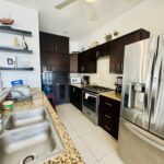 Kitchen with granite counters, dark cabinetry, and stainless appliances